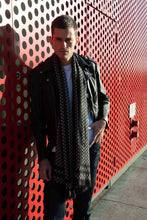 Load image into Gallery viewer, Drape  ärtskül’s Baby Pop, Nana Rectangle scarf with a leather coat.  Soft, lightweight and warming - there's so many ways to drape it.  It's the must have classic black and white printed cashmere blend scarf. Looks like houndstooth with a bit of a surprise.