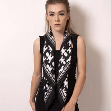 Load image into Gallery viewer, Transform the Baby Pop square scarf into a vest with a simple fold. You&#39;ll be anything but basic with this black and white scarf that features the reimagined houndstooth pattern with the baby icon framed by a border that creates interesting styling options when folded.