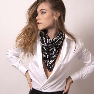 Artskul's chic black and white logo scarf is styled as a neck scarf. Elevate your style with luxury street style edge.
